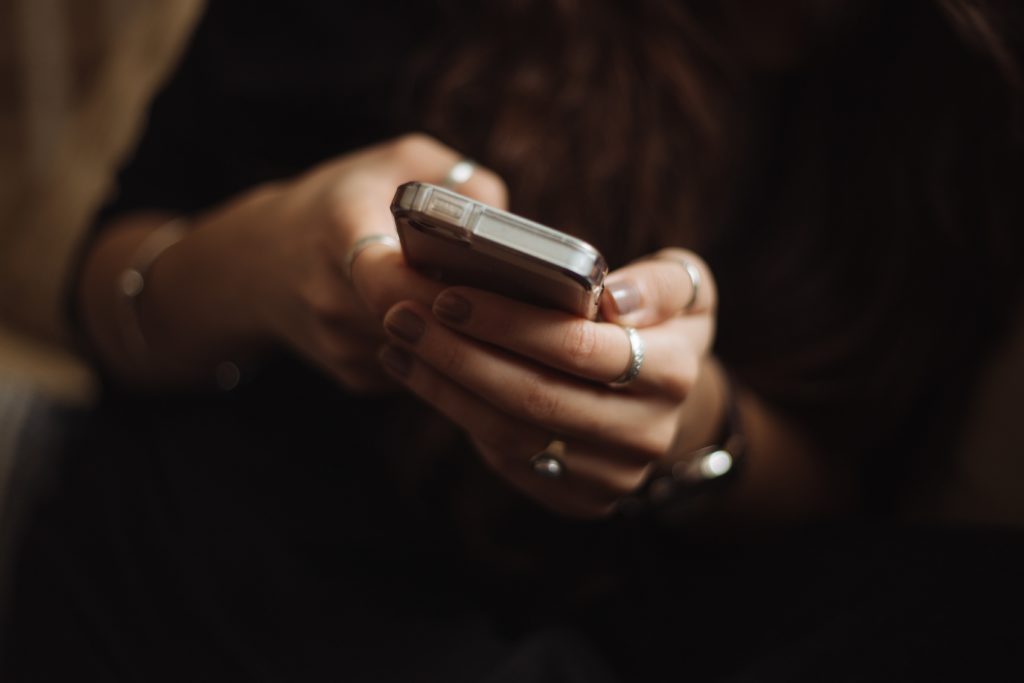 Frau mit Smartphone Wie schreibe ich einen Mann an?